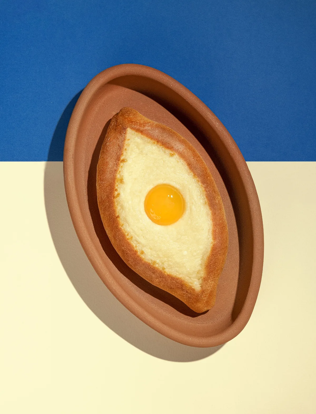 Chizzzy Acharuli Khachapuri served on a Georgian clay dish