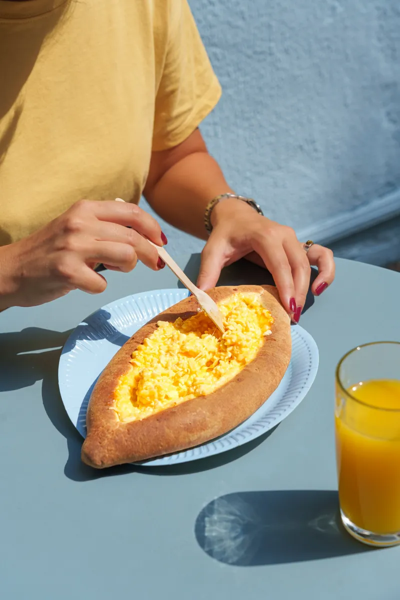 Mixing melted cheese in freshly baked Chizzzy Acharuli Khachapuri